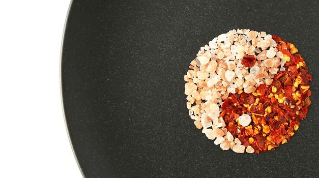 yin yang food ingredients. Himalayan salt chili pepper in red black colour on white background