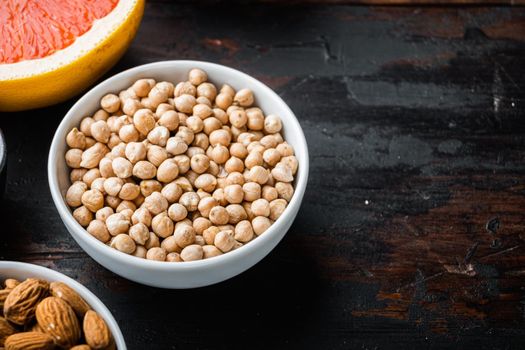 Chickpea in white bowl on dark wooden background, with copy space.
