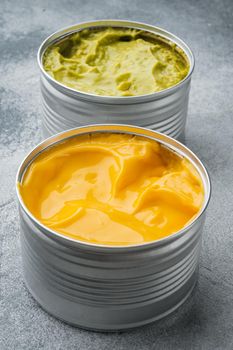 Canned guacamole and cheese dip in can, on gray background