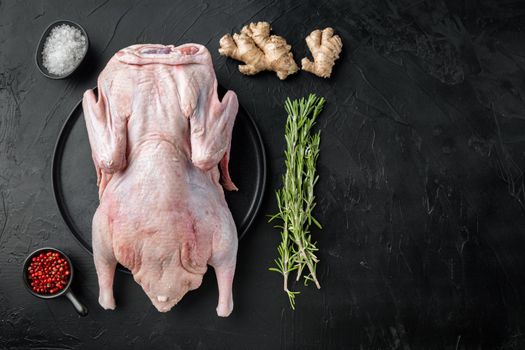 Fresh raw whole duck meat on black background, top view, with copy space.