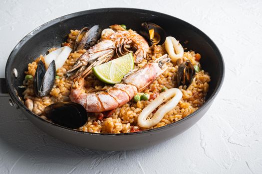 Paella with seafood and chicken on white background, food photo.