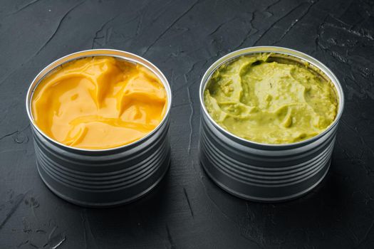 Canned cheese and guacamole sauce in can, on black background