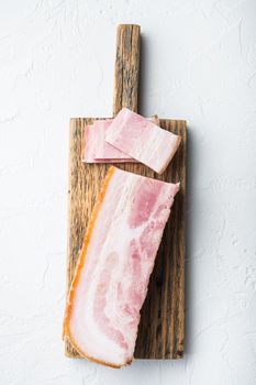 Smoked bacon, whole slab on white background, top view.