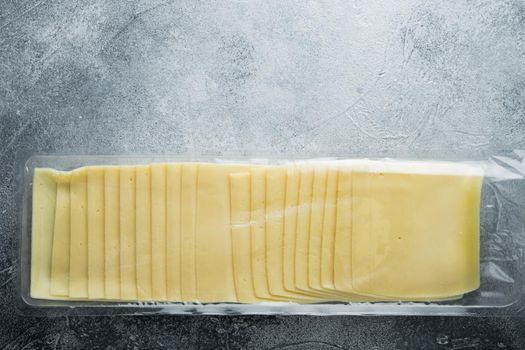 Cheddar cheese in vacuum pack, on gray background with copy space for text
