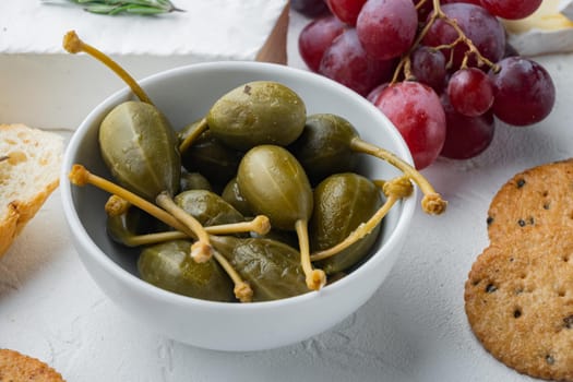 Capers, marinated in oil, on white background
