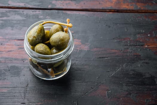 Organic pickled, canned capers, on old wooden table with copy space for text