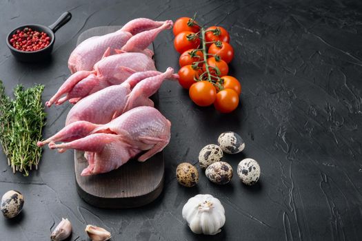 Fresh raw meat quail ready for cooking, on black textured background with space for text