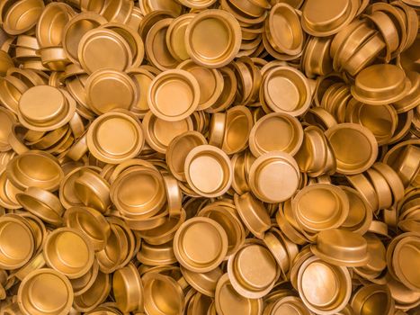 pile of stamped thin sheet brass hat-shaped semimanufatures, full frame industrial manufacturing background