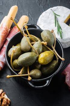 Organic pickled, canned capers, on black background