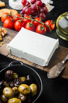 Ingredients for traditional greek salad set, on black wooden table