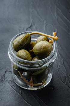 Organic pickled, canned capers, on black background