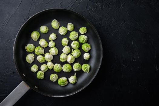 Raw brussels sprouts, on black textured background, top view with space for text