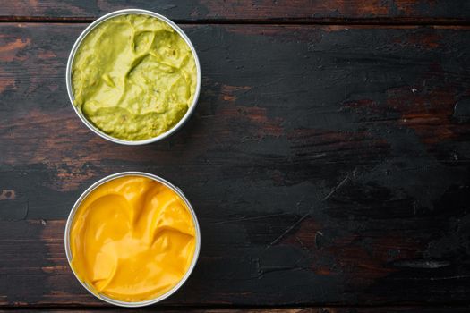 Canned cheese and guacamole sauce in can, on old wooden table, top view or flat lay with copy space for text