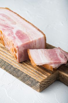 Smoked bacon, whole slab on white background.