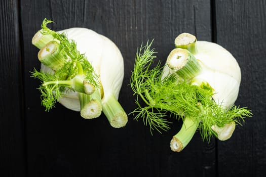 Fresh organic fennels, on black wooden table, flat lay