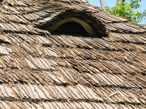 Attic window of an old wooden house decorated with wood carvings