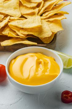 Bowl with cheese dip with nacho, on white background