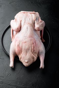 Whole raw duck meat on black background.