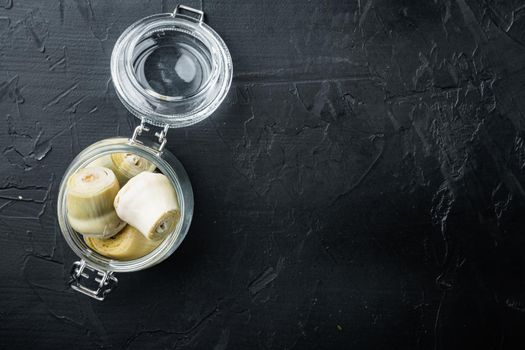 Artichoke hearts set, on black textured background, flat lay with space for text