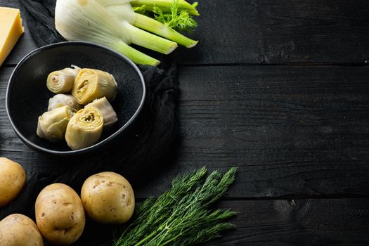 Artichoke hearts set, on black wooden table with space for text