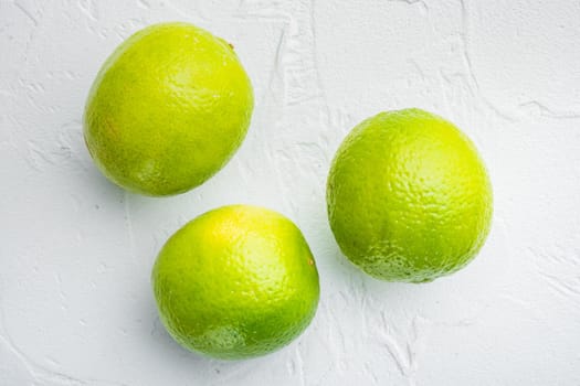 Whole green lime set, on white background, top view or flat lay
