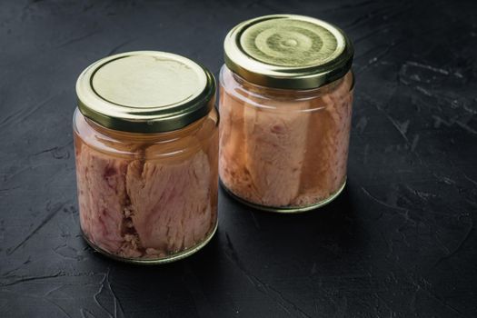 Tuna fillet canned in glass, on black background