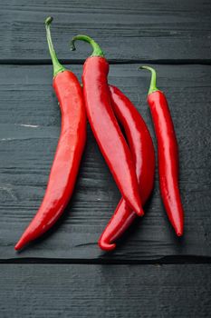 Whole red chili peppers set, on black wooden background