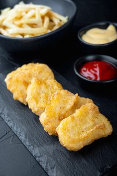 Chicken breast nuggets fried on black background.