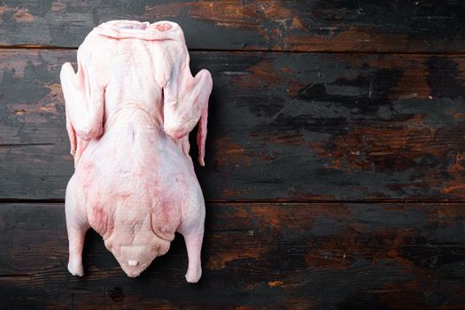 Fresh raw whole duck meat on dark wooden background, top view, with space for text.