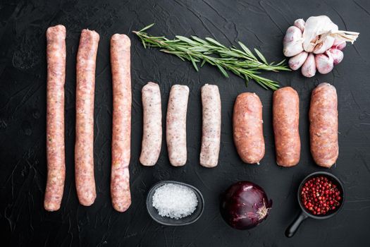 Raw sausages set, top view, on black background.
