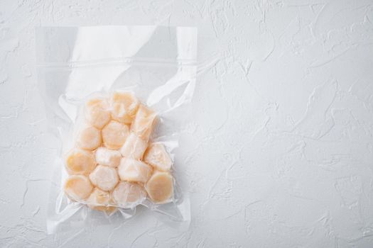 Frozen meat scallops in vacuum package, flat lay, on white textured background with space for text