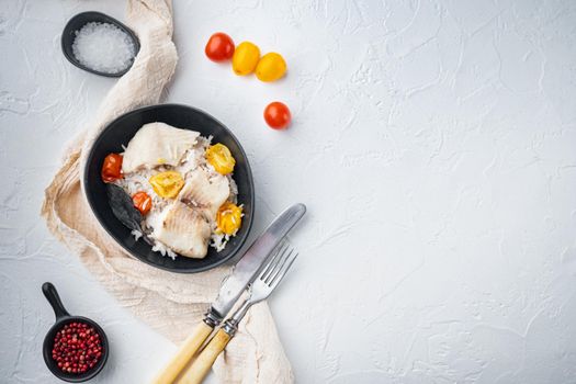 Tilapia fish with basmati rice and cherry tomatoes, in bowl, on white background, top view with copy space for text