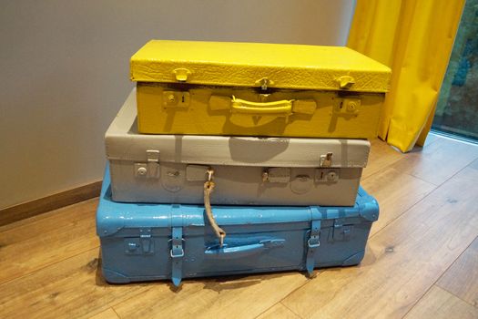 three old-fashioned suitcases in the corner by the window close up