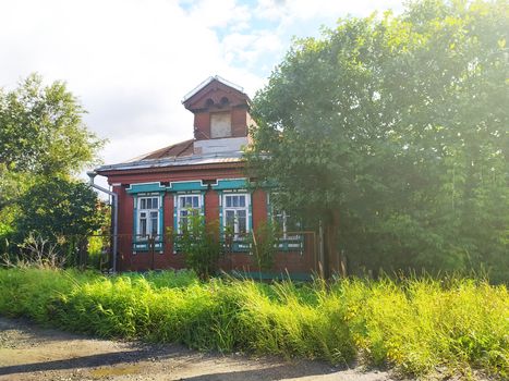 rustic wooden house with a mezzanine on a sunny lawn.