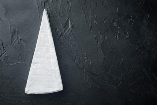 Brie type of cheese set, on black background, flat lay with copy space for text