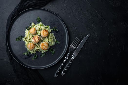 Seafood, scallops grilled with minty potatoes and pea, top view, on black textured background with copy space