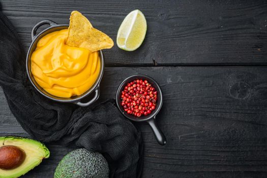 Bowl with beer cheese dip sauce, on black wooden background, top view or flat lay with copy space for text
