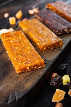 Healthy fitness energy bars with dried fruits and nuts, on wooden table