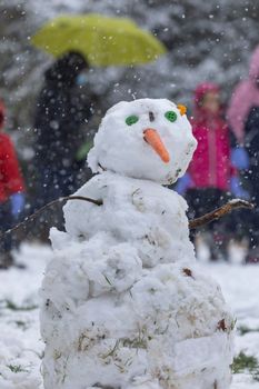 Madrid, Spain - January 08, 2021: Children playing with snow and making snowmen, in the Buen Retiro park in Madrid, in the middle of a snowy day, due to a wave of polar cold.