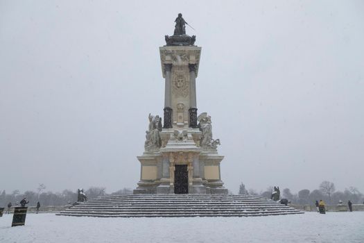 Madrid, Spain - January 08, 2021: Monument to Alfonso XII in Retiro park, Madrid, in the middle of a snowy day, due to a wave of polar cold.