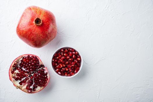 Ripe pomegranate with juicy seeds, on white textured background, top view with space for text