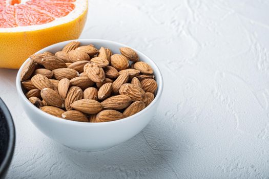 Almonds nuts in bowl with space for text, on white background.