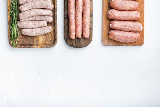 Set of pork, beef and chicken sausages, flat lay with space for text, on white background.