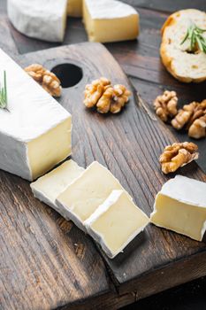 Slice of brie farmhouse creamy soft cheese set, on dark wooden background