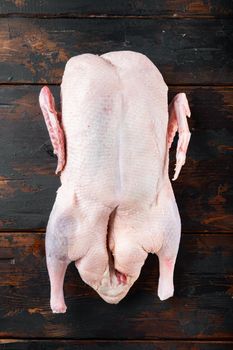 Recipe for cooking whole duck meat on old dark wooden table, flat lay.