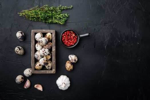 Fresh quails eggs, flat lay, on black textured background with space for text
