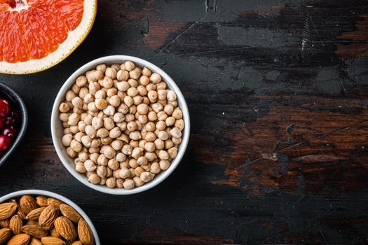 Chickpea in white bowl, top view on dark wooden background, with copy space.