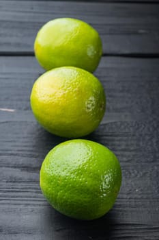 Ripe green lime set, on black wooden background