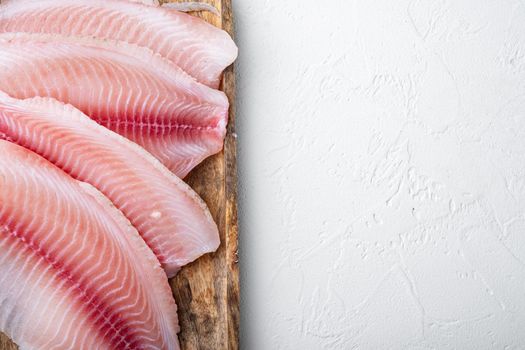 Tilapia fish, skinless meat, on white background, top view with copy space for text