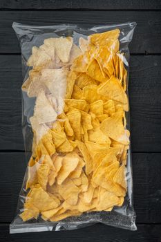 Package corn traditional nachos bag, on black wooden background, top view or flat lay